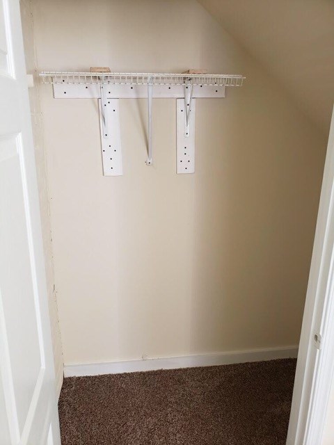 a closet with a shelf and hooks on the wall